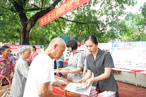 工作人员向市民发放扫黑除恶宣传资料。