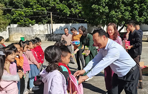 南宁市龙翔学校向南圩镇四联村小学贫困学生赠送学习用品。