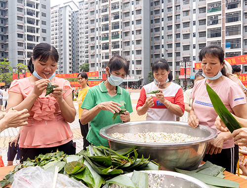 社区居民积极参与包粽子。