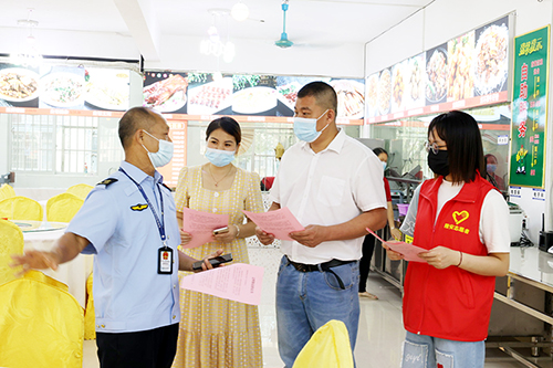 志愿者在餐馆为市民普及文明餐桌理念。