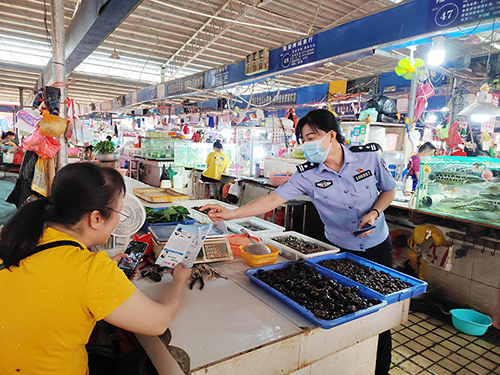 民警在农贸市场进行反诈宣传。