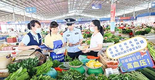 工作人员向农贸市场的商贩进行非法集资宣传。