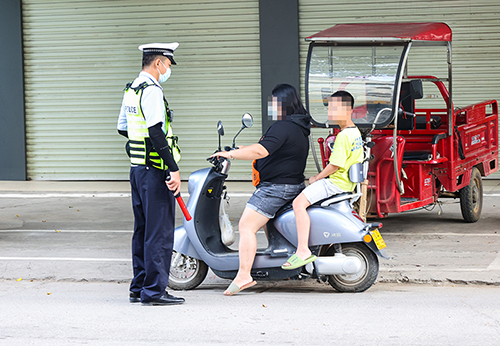 交警劝导市民佩戴头盔。