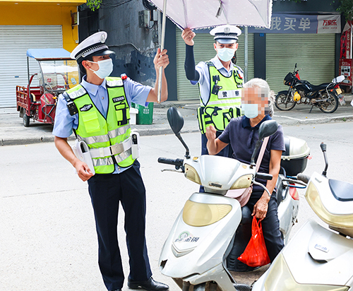 交警对存在安全隐患的雨伞进行拆除。