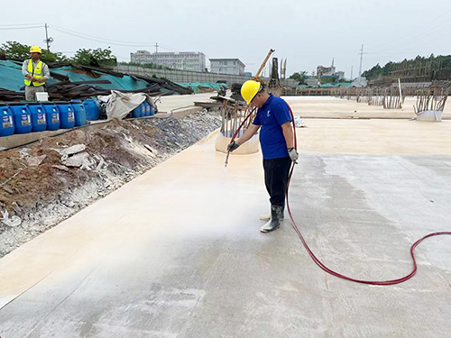 姚志强在工地现场试验新材料对水泥基面的封闭性。