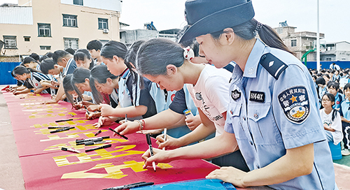 民警带领同学们签署禁毒承诺。