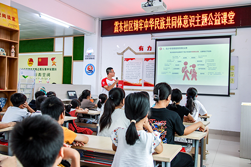 小朋友们认真聆听大学生志愿者授课。（易了然　摄）